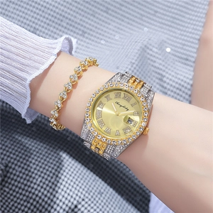 Close-up of luxury women's watch set with crystal-encrusted gold band and calendar dial