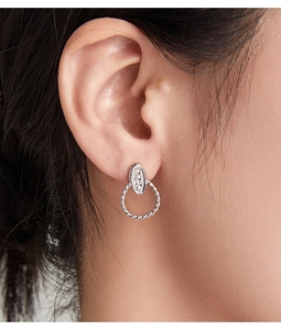 Detailed view of silver hoop earrings with pavé crystals and twisted texture on model