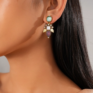 Détail de boucle d'oreille vintage avec pierres en résine colorées et finition dorée