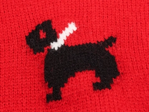 Detail of red knitted fabric featuring a black and white terrier intarsia pattern