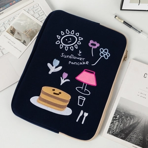 Detail of sunflower and pancake embroidery on navy blue laptop sleeve with beige zipper