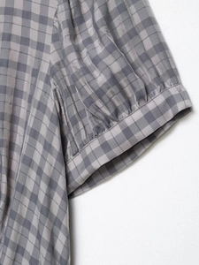 Detail of grey gingham short sleeves with puff design and fine pleated cuff tailoring