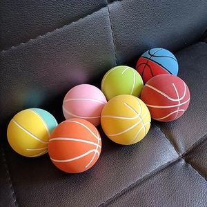 Macro view of colorful 6cm mini elastic basketball stress balls on dark texture