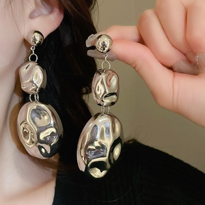 Detail showing silver liquid-metal textured triple oval drop earrings on model