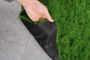 Detail shot of the thick artificial green moss turf showing the black fabric backing