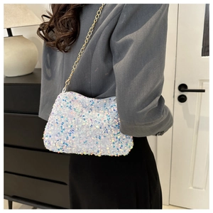 Model wearing a white iridescent sequin chain bag over a grey suit jacket