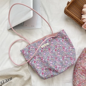 Gros plan détaillé d'un sac cabas en toile fleurie avec anses roses et étiquette Sorakka