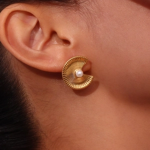 Detailed view of an 18K gold plated shell-shaped earring featuring a central pearl inlay