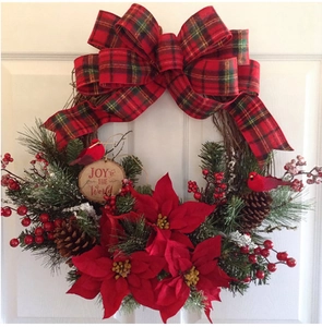 Detail of Christmas wreath with red poinsettia, pine cones and JOY to THE WORLD sign
