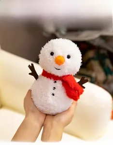 Close-up of cute plush snowman with carrot nose and red scarf for Christmas gift
