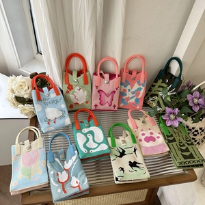 Detailed close-up of cute animal and floral knitted handbags lined on a wooden table