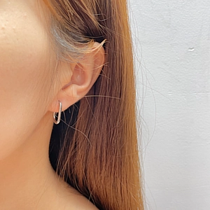 Minimalist silver oval stainless steel earrings shown on a model for a modern look