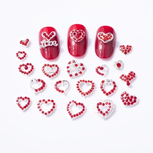 Detailed view of red heart nail charms and silver metal alloy gems for nail art design