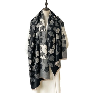 Elegant thick cashmere-like scarf with ginkgo leaf pattern and fringe on a model stand