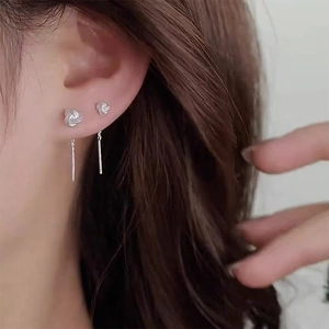 Detail view of 925 silver twist knot dangle earrings on model with a minimalist sleek finish