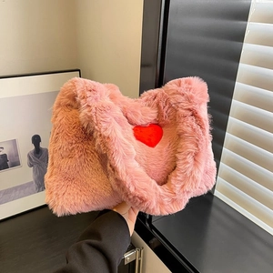 Detailed view of pink plush handbag featuring a soft faux fur texture and a red heart