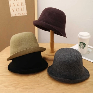 Dettaglio di cappelli in lana in quattro colori con tesa arrotolata e trama morbida