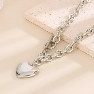 Detailed view of silver heart pendant and toggle clasp on thick link chain necklace