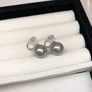 Macro shot of grey pearl clip-on earrings with soft silicone pads in a black jewelry box