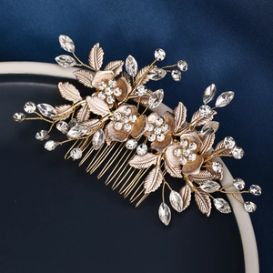 Detail of gold floral hair comb with delicate leaves and sparkling rhinestones
