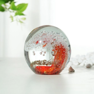 Boule de verre cristalline avec vagues et bulles interieures pour decoration de table.