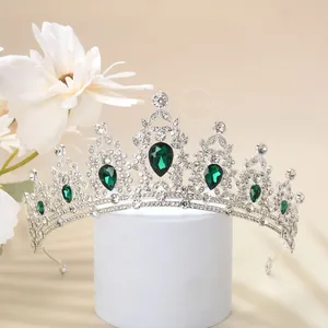 Detailed view of luxury silver crown with green teardrop crystals and white diamonds