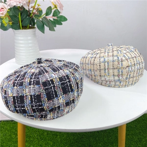 Close-up of classic checkered tweed beret hats with vintage woven texture in autumn colors