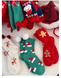 Détail des chaussettes de Noël en polaire corail avec décorations 3D et nœuds rouges