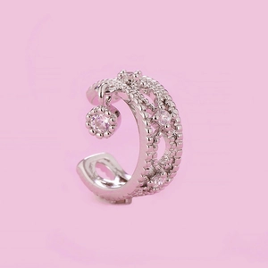 Close-up of silver ear cuff with sparkling zircons and a round pendant detail
