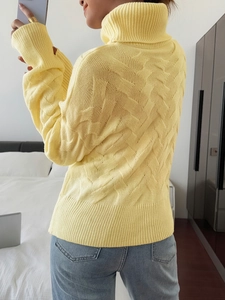 Rear view of yellow high neck knit sweater featuring cable patterns and long sleeves