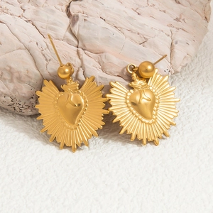 Exaggerated 18K gold plated stainless steel heart sunburst earrings on stone background