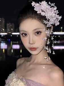 Detail of Lily of the Valley hair clip with purple tassels on a model in night scene