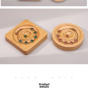 Detail view of heart-shaped pink and round green gemstone jewelry on wooden display trays