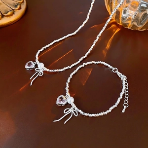 Silver beaded necklace and bracelet set with pink heart crystal and bow pendant