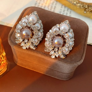 Detailed macro shot of vintage court style pearl earrings with rhinestones on velvet
