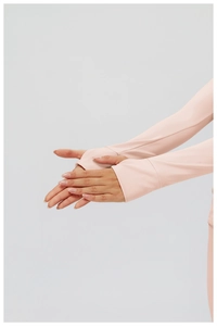 Gros plan détaillé des poignets du haut de sport rose avec design passe-pouce