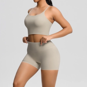 Detail of high-waisted yoga shorts and thin strap sports bra set in beige stretch fabric