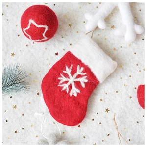 Close-up of handmade red wool felt Christmas stocking with snowflake embroidery and gold sequins