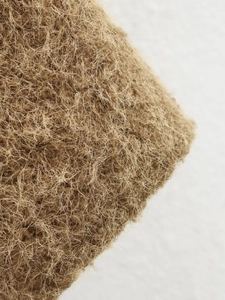 Detailed close-up of natural brown fiber material showing dense organic texture