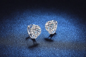 Macro shot of silver sunflower huggie earrings with round moissanite cluster setting