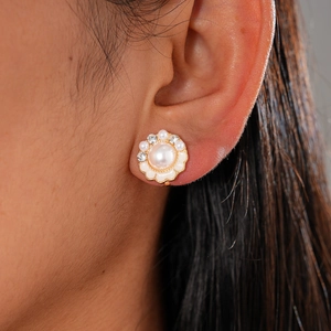 Floral pearl earrings with rhinestones on gold base, shown worn on ear for style