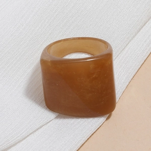 Macro detail of amber resin ring showing translucent geometric texture on white fabric