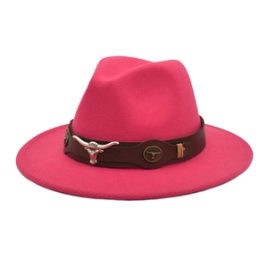 Close-up of rose red wool fedora with brown leather band and silver bull head emblem
