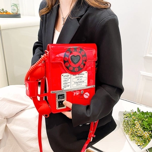 Close-up of a creative red retro telephone crossbody bag featuring a dial and handset