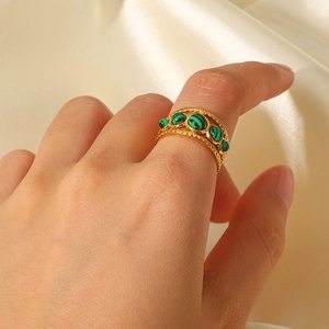 Gold multi-layer stainless steel ring with green malachite stones on a silk background
