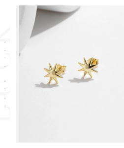Detail shot of golden S925 sterling silver sunburst stud earrings with Good Luck text