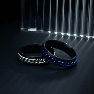 Macro shot of 6mm black stainless steel spinner rings with silver and blue chain inlays