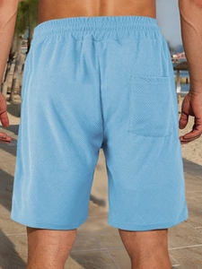 Detailed back view of men's bright blue waffle knit shorts with elastic waist and back pocket