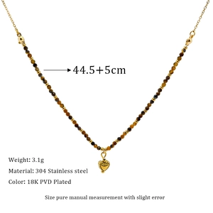 Detail of beaded necklace with tiger eye stone and 18K PVD plated heart pendant