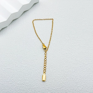 Detail of gold metal minimalist link chain bracelet with lobster clasp and extender